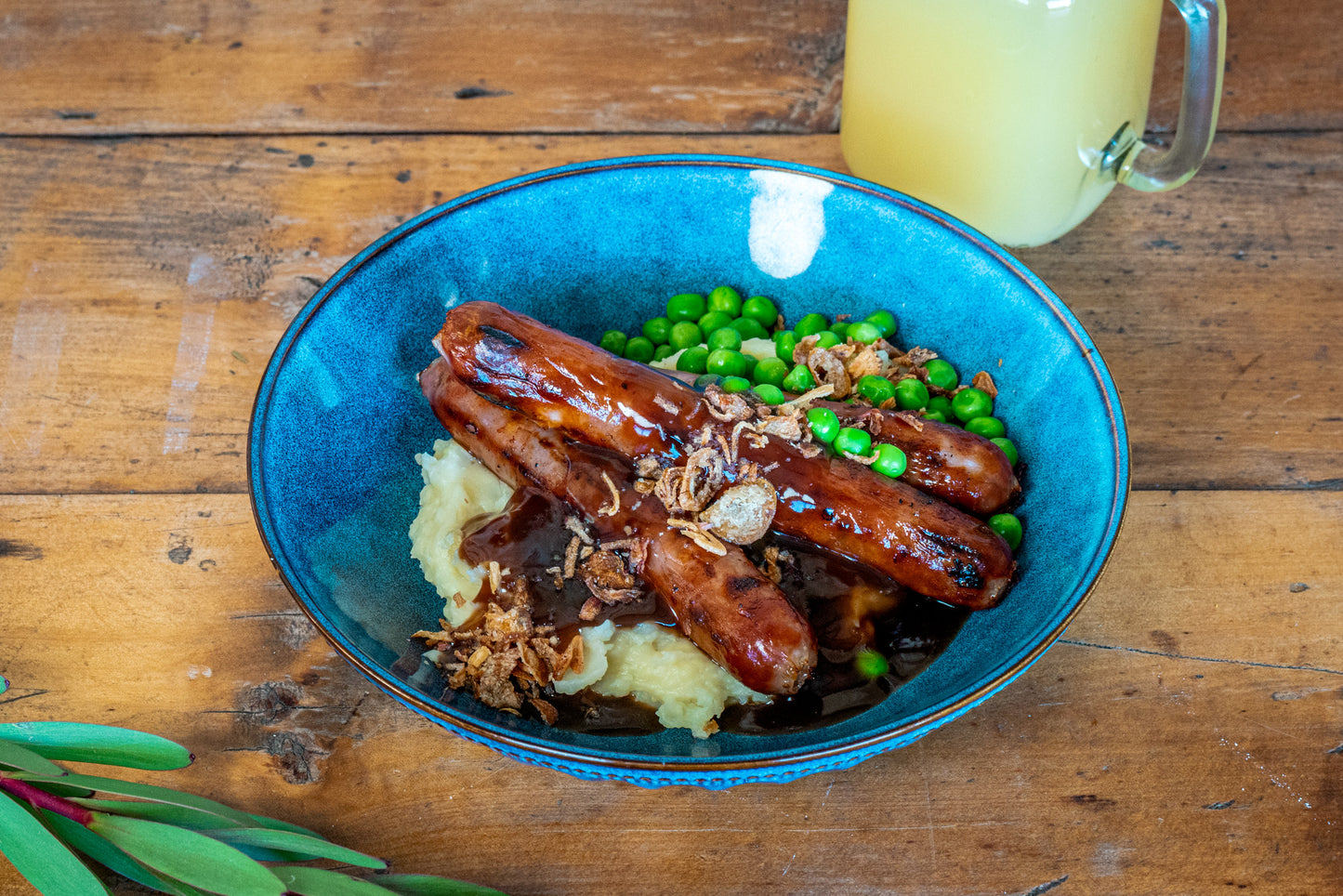 A photo of Bearded Dragon Hotel's signature dish, Bangers and Mash served with Peas and Crispy Onions